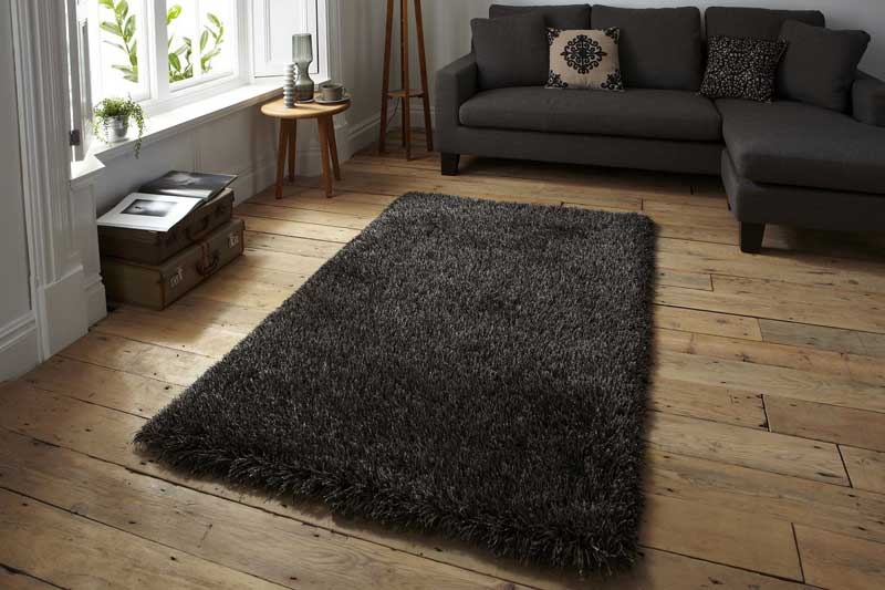 Черный ковер на деревянном полу